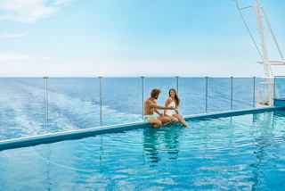 Un couple profite d'un moment serein dans la piscine à débordement avec vue sur la mer et le ciel | MSC Cruises