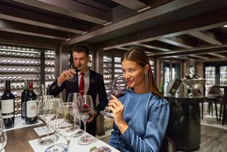 A couple enjoys a wine tasting experience at The Wine Cellar on MSC Seashore | MSC Cruises