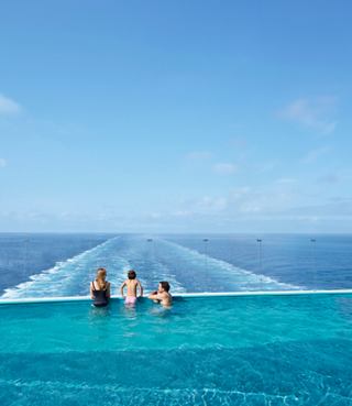 Des familles profitant de la piscine à débordement avec une vue imprenable sur la mer sous un ciel ensoleillé | MSC Croisières