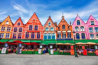 Bunte Gebäude säumen einen Marktplatz in Brügge und laden Besucher zur Erkundung und Aufregung ein | MSC Cruises