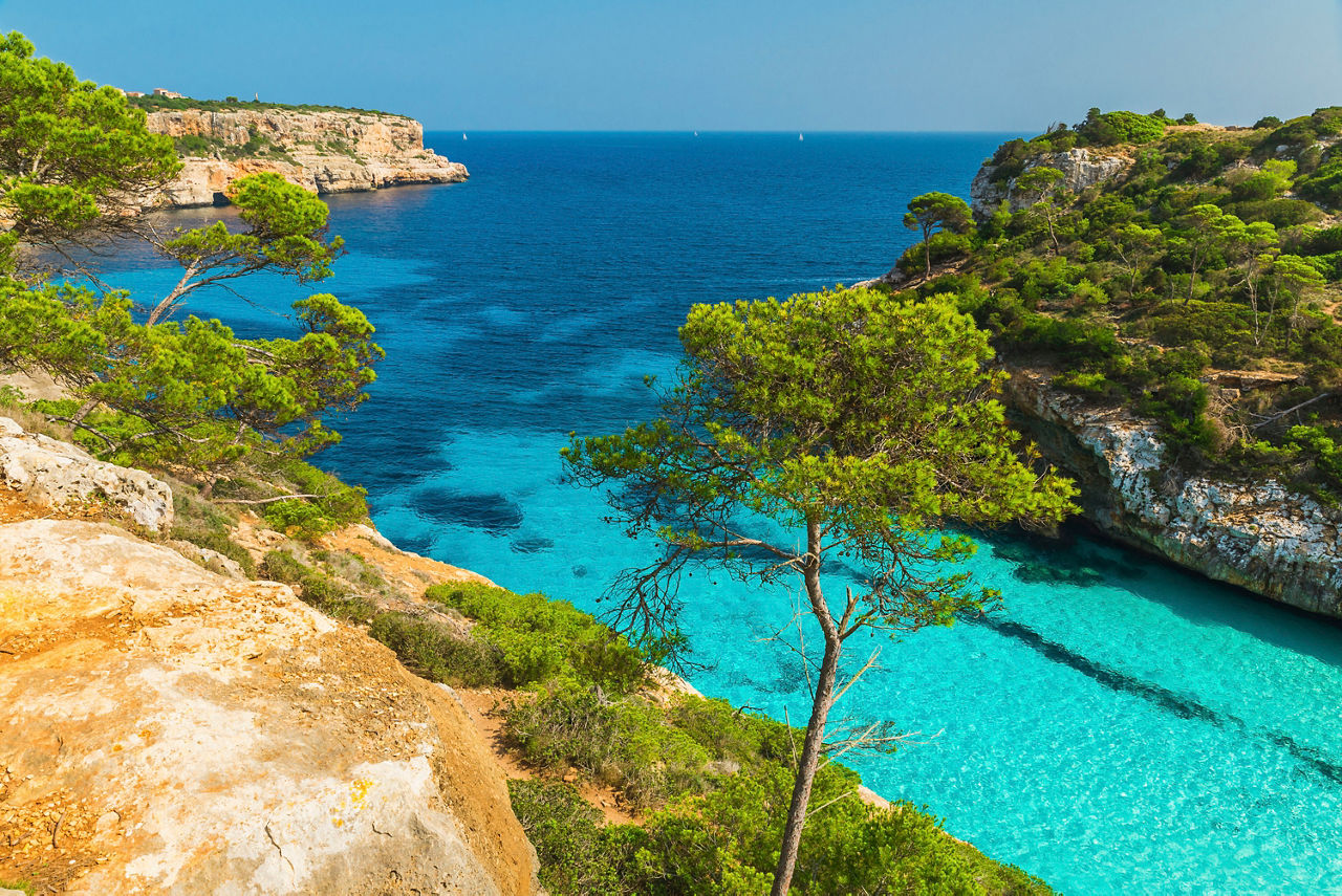 A stunning view of crystal-clear waters and rocky cliffs in a beautiful bay in Mallorca, Spain | MSC Cruises