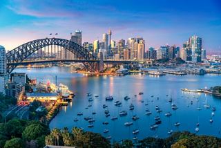 Une vue époustouflante de la skyline de Sydney avec le Harbour Bridge devant un coucher de soleil vibrant sur l'eau | MSC Cruises