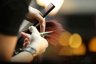 A close-up of hands skillfully cutting hair, showcasing a beauty treatment in the MSC Aurea Spa | MSC Cruises