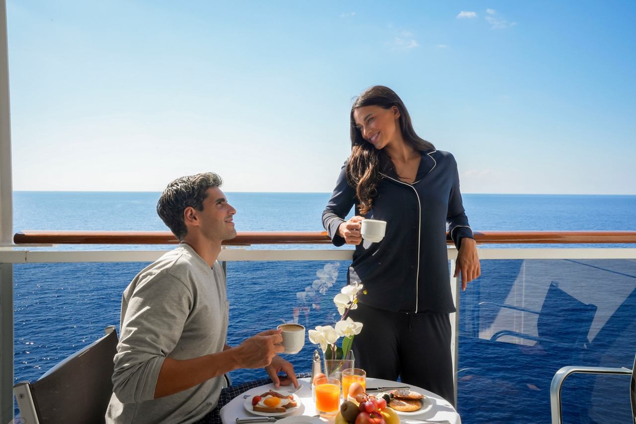 A couple enjoys breakfast on their balcony with a stunning sea view, creating a perfect moment on MSC Sinfonia | MSC Cruises