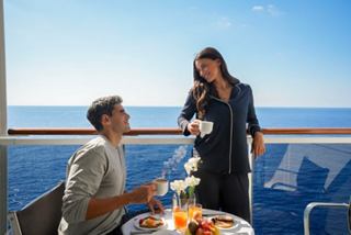 A couple enjoys breakfast on their balcony with a stunning sea view, creating a perfect moment on MSC Sinfonia | MSC Cruises