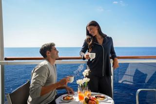 A couple enjoys a delightful breakfast on their balcony, overlooking the sea and sky | MSC Cruises