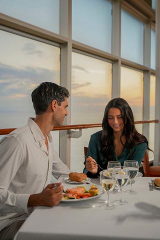 Two guests enjoying a meal together with beautiful ocean views at a restaurant on MSC Sinfonia | MSC Cruises