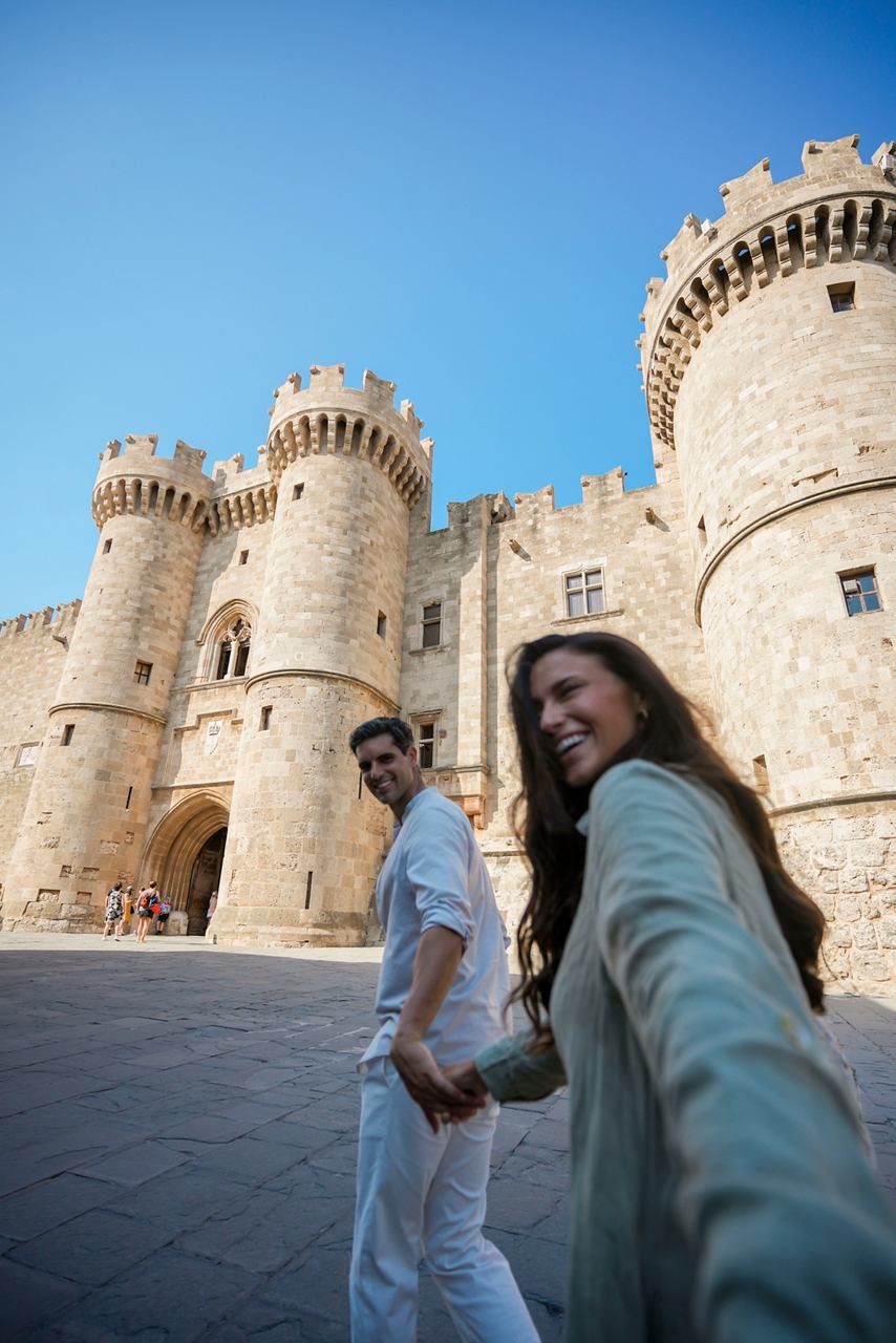 Una pareja explora el castillo histórico en Rodas, disfrutando de su aventura juntos bajo un cielo azul claro | MSC Cruises
