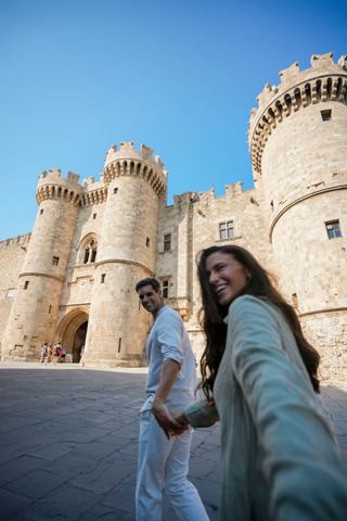 A couple explores the historic castle in Rhodes, enjoying their adventure together under a clear blue sky | MSC Cruises