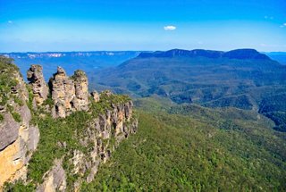 A panoramic view of the Three Sisters rock formation in the Blue Mountains, surrounded by lush vegetation and a clear sky | MSC Cruises