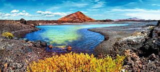 Vibrant landscape featuring a serene lake surrounded by colourful vegetation and a distant mountain peak | MSC Cruises