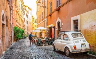 Une rue charmante à Trastevere, Rome, avec une voiture classique et un homme qui passe | MSC Croisières