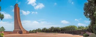 The Laboe Naval Memorial stands tall against a clear blue sky, surrounded by trees and visitors exploring the area | MSC Cruises