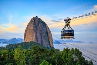 A cable car glides over lush greenery towards the iconic Sugarloaf Mountain in Rio de Janeiro's stunning landscape | MSC Cruises