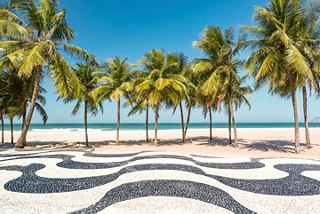 A beautiful view of Copacabana beach with palm trees and a decorative mosaic sidewalk | MSC Cruises