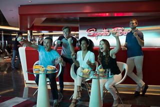 A group of friends enjoying snacks and drinks at the Sports Bar on MSC Meraviglia, celebrating together with smiles | MSC Cruises