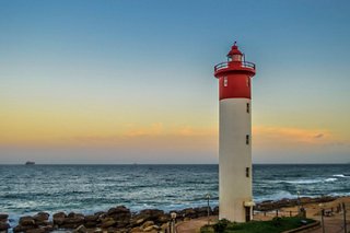 Un far impresionante se alza junto a la costa en Umhlanga, Sudáfrica, con el cielo y el mar de fondo | MSC Cruceros