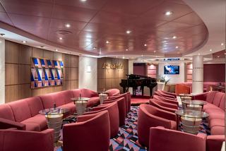 A cosy lounge area with plush seating and a piano, inviting relaxation and socialising onboard MSC Opera | MSC Cruises