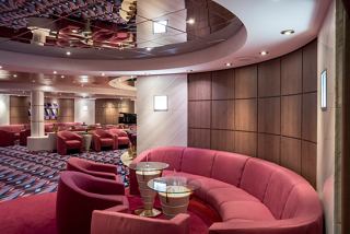 A stylish lounge area with comfortable seating arrangements and a piano, inviting relaxation and socialising | MSC Cruises