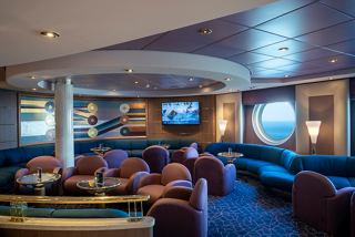 A welcoming lounge area onboard MSC Opera, featuring comfortable seating and large portholes overlooking the sea | MSC Cruises