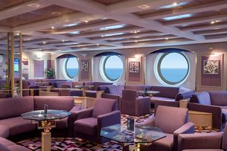 A comfortable sitting area with plush seating and portholes, inviting relaxation and sea views | MSC Cruises