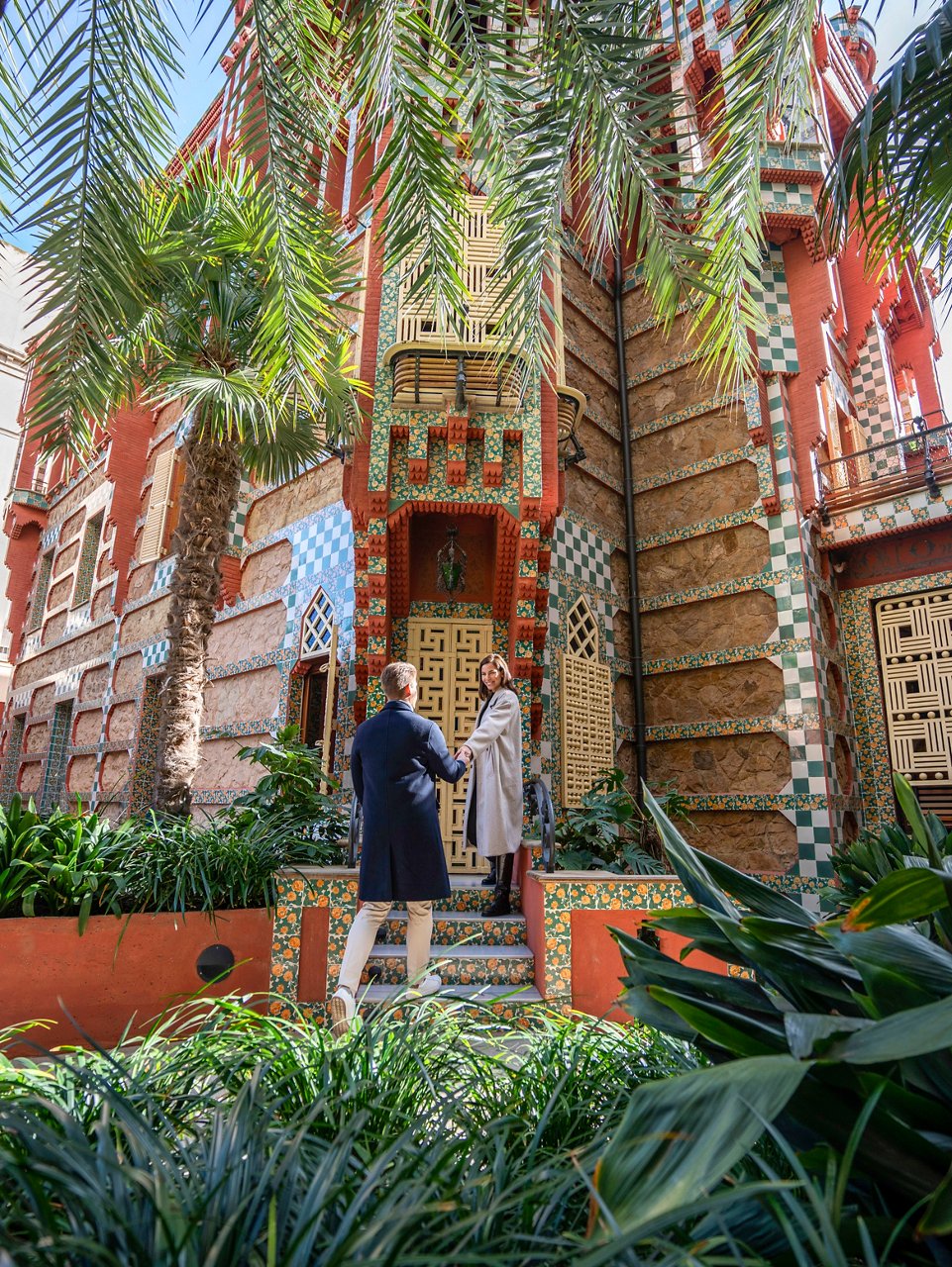 Una pareja está junta en la entrada de Casa Vicens, rodeada de exuberante vegetación en Barcelona | MSC Cruises