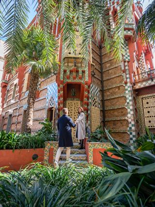 Una pareja está junta en la entrada de Casa Vicens, rodeada de exuberante vegetación en Barcelona | MSC Cruceros