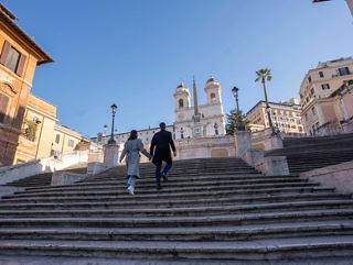 A couple walking up the Spanish Steps in Rome, with the iconic obelisk and buildings in the background | MSC Cruises