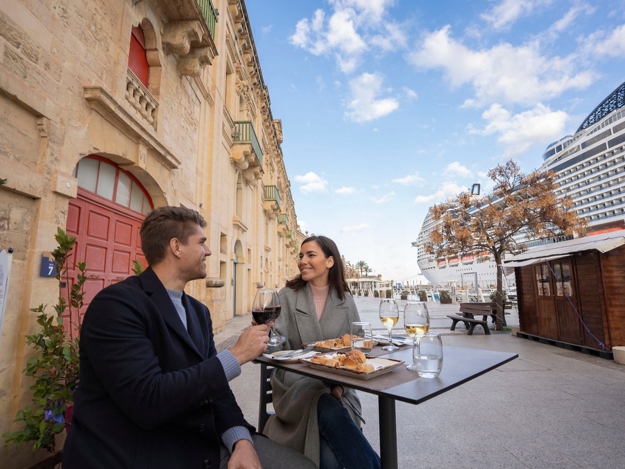 A couple enjoying a delightful meal together at a café in Valletta, Malta, with a scenic view | MSC Cruises