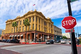 A historic building in Galveston with a vibrant street scene and a stop sign nearby | MSC Cruises