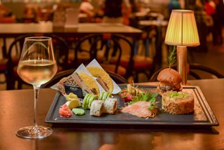 Una bandeja bellamente dispuesta de delicias gourmet sobre una mesa con luz cálida y un ambiente acogedor | MSC Cruceros