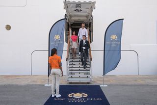 Guests stepping onto the blue carpet at the MSC Yacht Club entrance aboard MSC World Europa | MSC Cruises