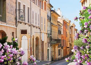 Charming narrow street lined with historic buildings and blooming flowers, embodying the spirit of Provence | MSC Cruises