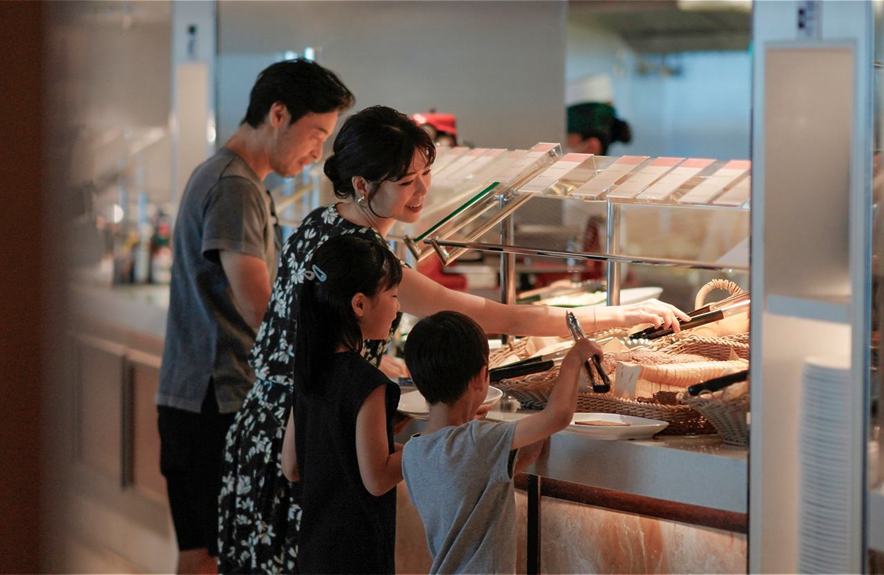 A family enjoys a meal together at the Marketplace Buffet, exploring delicious options on MSC Bellissima | MSC Cruises
