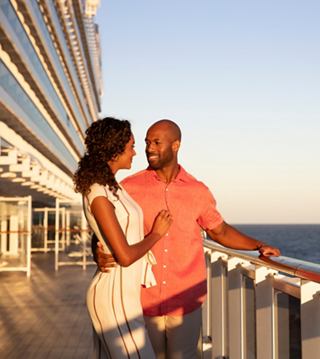 A couple enjoys a romantic moment on deck, surrounded by sunset views of the sea and sky | MSC Cruises