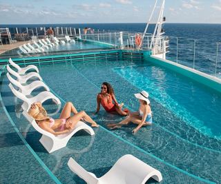 Los huéspedes se relajan en la piscina infinita de un barco de crucero, disfrutando de la impresionante vista del océano | MSC Cruceros