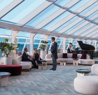 Los huéspedes disfrutan de un ambiente relajado en el elegante Top Sail Lounge a bordo del MSC World Europa | MSC Cruceros