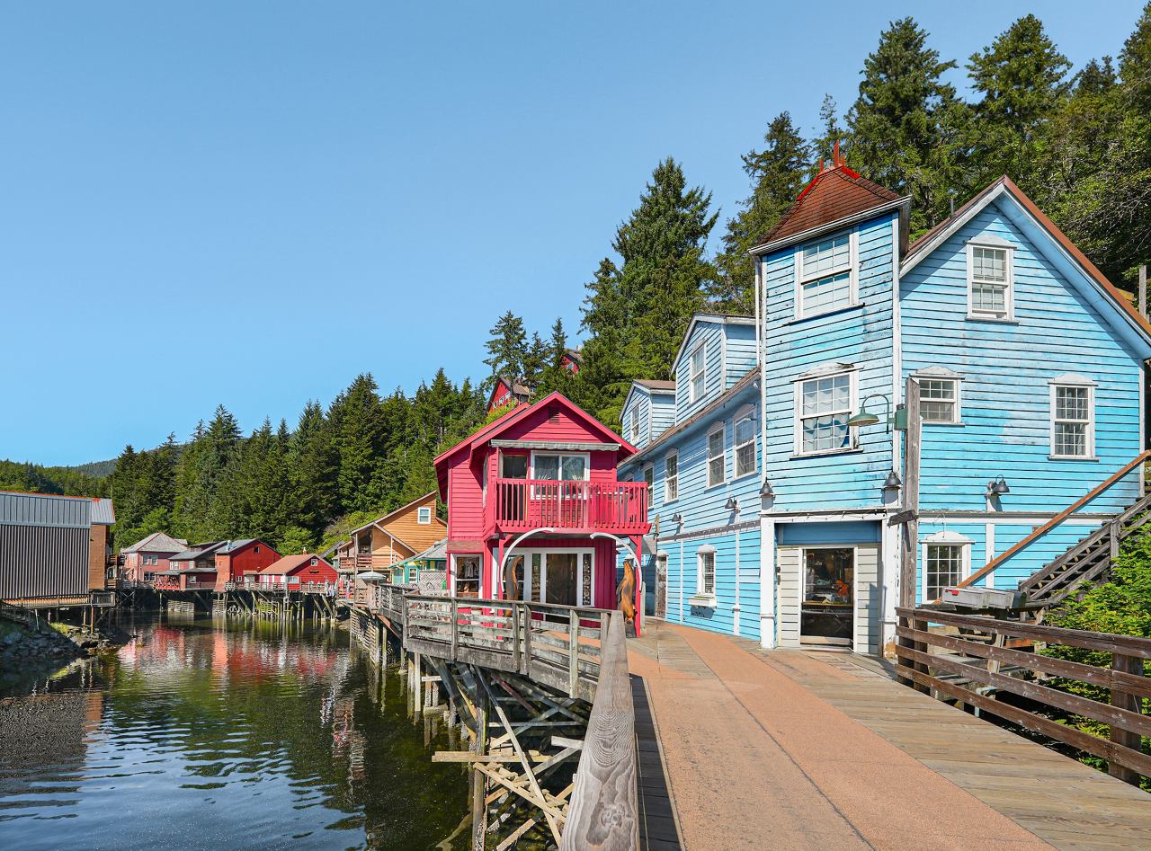 Charmante Gebäude säumen die Uferpromenade entlang eines ruhigen Baches in Ketchikan, Alaska, und laden zur Erkundung und Abenteuer ein | MSC Cruises