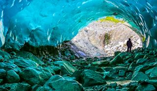 Cueva de hielo en Alaska con una persona disfrutando de la belleza natural | MSC Cruceros