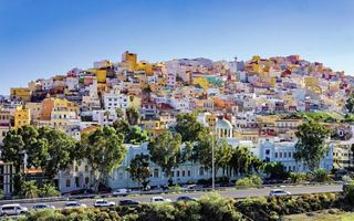 A vibrant hillside view of Las Palmas in Gran Canaria, showcasing colourful buildings against a clear blue sky | MSC Cruises