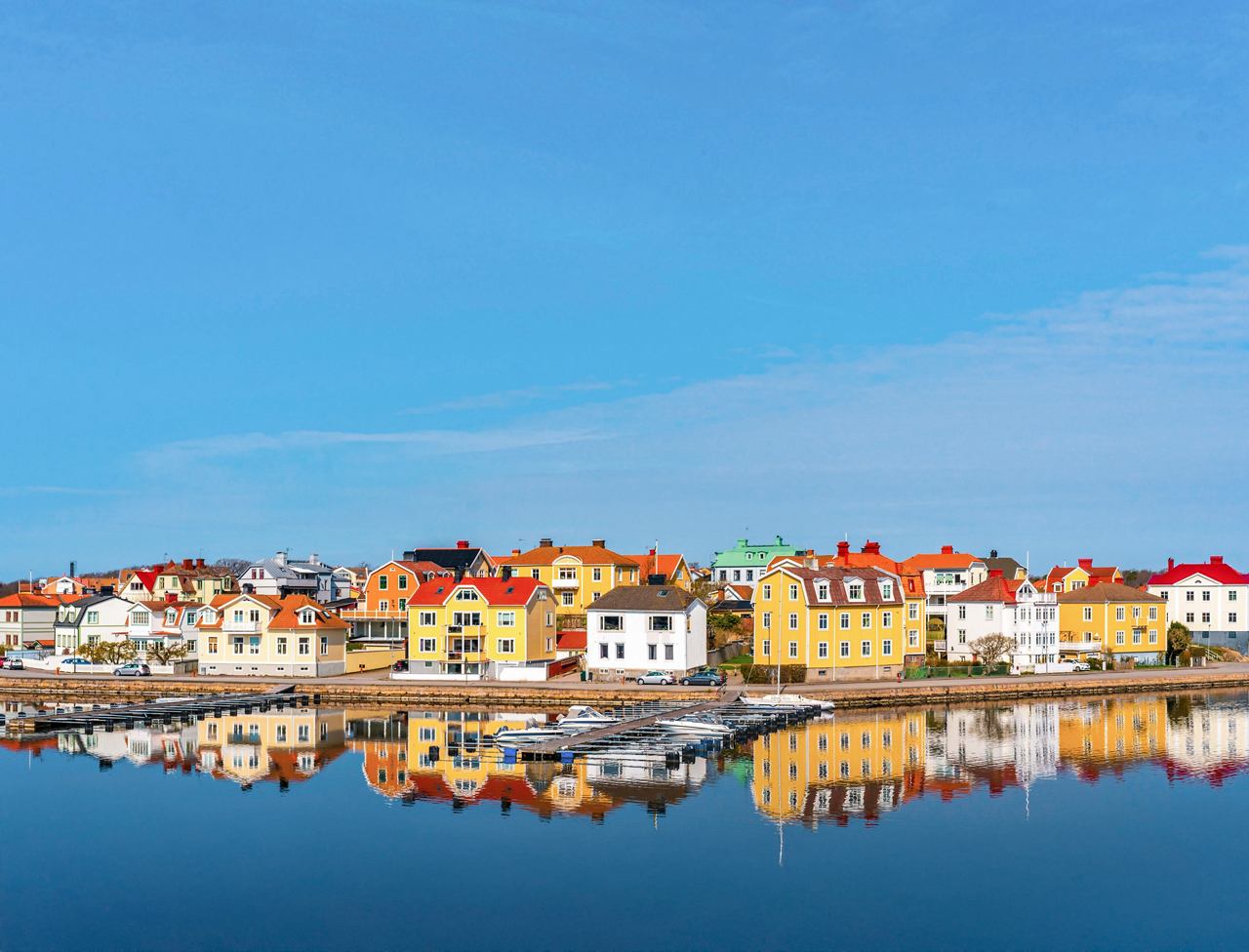 Bunte Gebäude spiegeln sich in ruhigen Gewässern unter einem klaren blauen Himmel in Karlskrona, Schweden | MSC Cruises