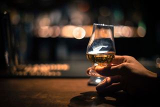 A hand holds a glass of whiskey, savoring a moment of relaxation | MSC Cruises