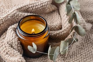 A candle surrounded by eucalyptus leaves resting on a soft towel in a crusie spa | MSC Cruises