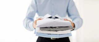 Young man holds neatly folded shirts with an elegant touch | MSC Cruises