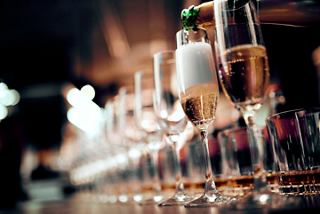 A bartender prepares drinks at the elegant bar of MSC Divina, showcasing a variety of glasses and champagne | MSC Cruises