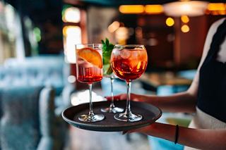 A waiter serves vibrant cocktails on a tray at the Foyer Bar in the Silver Lounge of MSC Divina | MSC Cruises