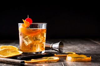 A vibrant cocktail garnished with orange and cherry, served in a glass, highlighting the Golden Jazz Bar on MSC Divina | MSC Cruises