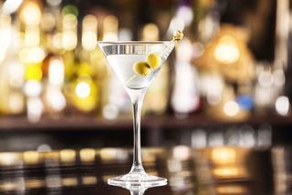 A refreshing dry martini served in a sleek glass, set against a vibrant bar backdrop | MSC Cruises