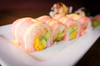 A close-up view of vibrant sushi rolls showcasing fresh ingredients on a white plate | MSC Cruises