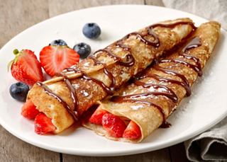 Delicious crepes filled with strawberries and drizzled with chocolate sauce on a plate | MSC Cruises